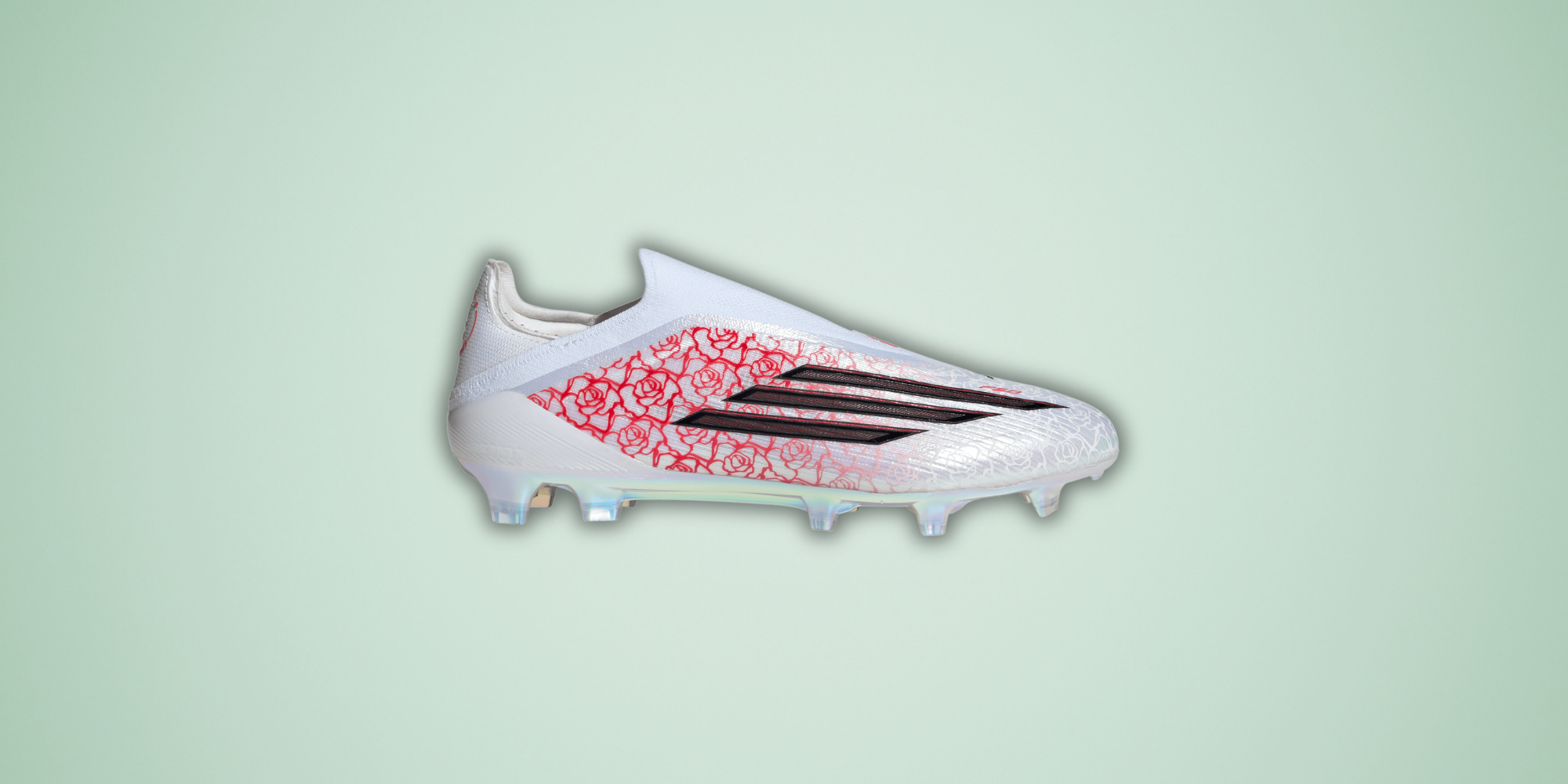 White soccer cleat with red and black design on a light green background
